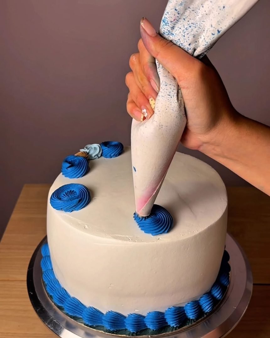 Decorando a mano un pastel con manga pastelera azul